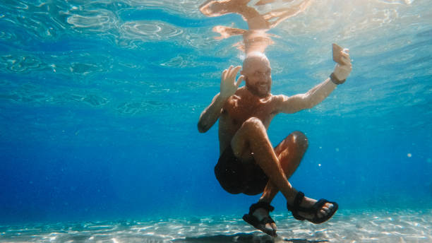 istock Selfie with mobile phone underwater at sea: summer craziness 1409891393