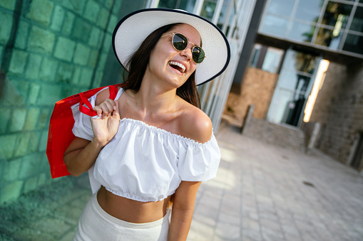 Happy young woman with bag enjoying in shopping and travel. Consumerism, shopping, lifestyle concept