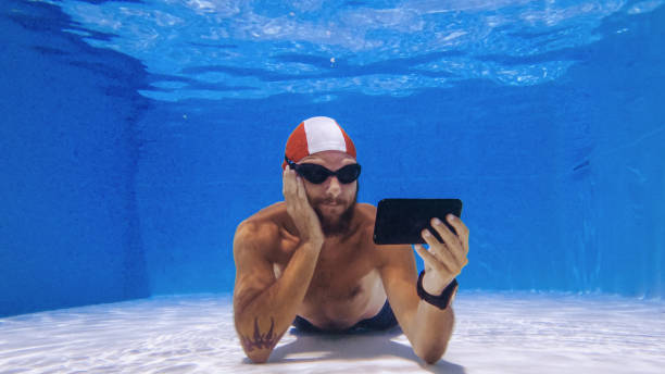 Binge watching with mobile phone underwater: social media addiction stock photo