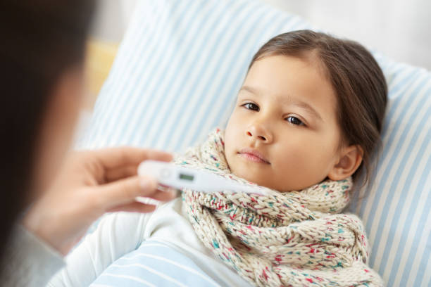istock mother measuring temperature of sick daughter 1409891833