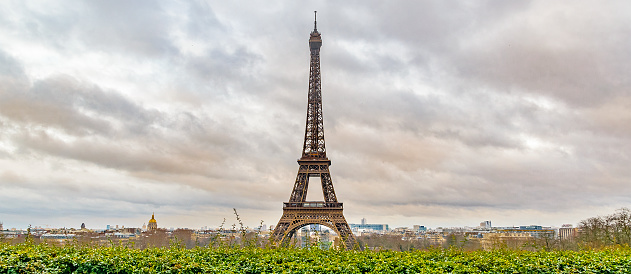 The Eiffel Tower seen in Springseason with a large Squar ebefore it with some traffic.