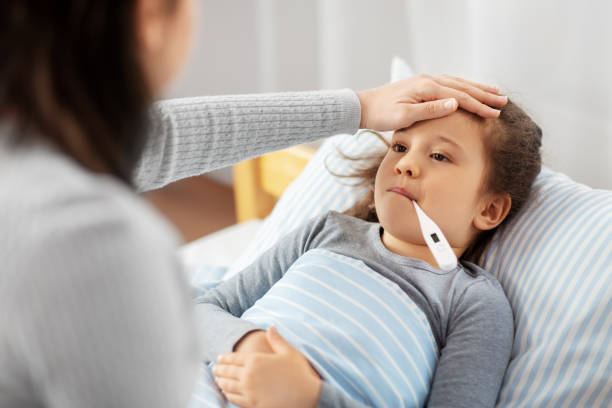 istock mother and sick daughter measuring temperature 1409891988