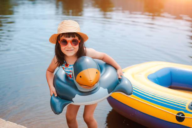 子供たちは夏休みに村の街の外の池で水遊びを楽しんでいます。 - water wings ストックフォトと画像