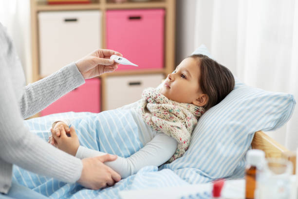istock mother measuring temperature of sick daughter 1409892763