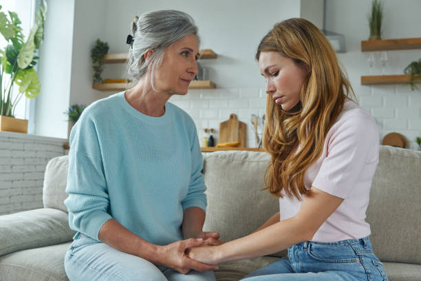 istock Frustrated young woman sharing problems with mother while both sitting on the couch at home 1409892969