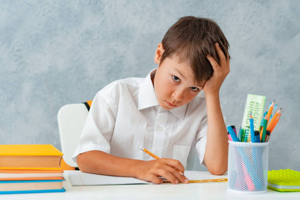 istock Back to school. Happy smiling student draws at the Desk. A schoolboy solves his homework. A boy from elementary school 1409895566