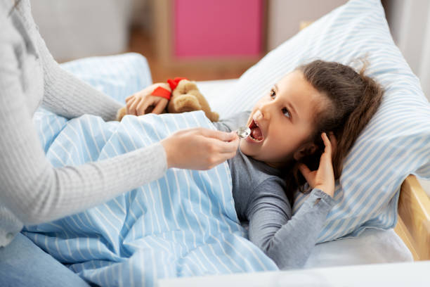 istock mother giving cough syrup to sick daughter 1409895603