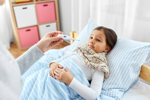 istock mother measuring temperature of sick daughter 1409895817