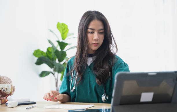 Asian Female doctor working at office desk. stock photo