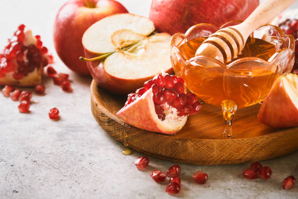 istock Rosh Hashanah. Pomegranate, apples and honey traditional products for celebration on rustic grey background. Jewish Autumn Rosh Hashana celebration. Jewish holiday Rosh Hashana design. Selective focus 1409896437