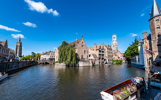 Bruges, Belgium. 16 July 2022. Wide shot of Bruges canal and architecture with tourist boats on the canal.