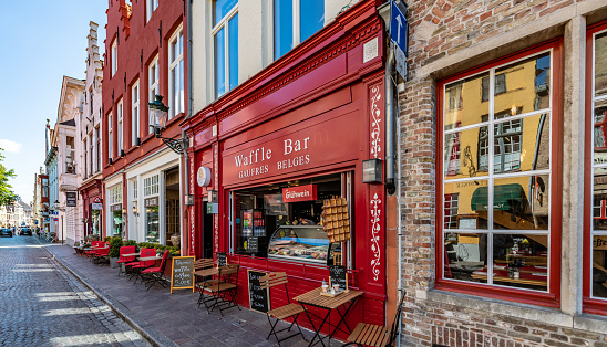 Bruges, Belgium. 16 July 2022. Street with a Waffle house in Bruges, street cafe.