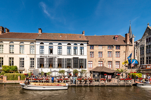 Bruges, Belgium. 16 July 2022. Tourists go on a popular boat tour of Bruges canals.