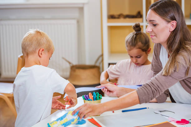 istock The teacher helping a child and they are working together making some paper crafts. Developing Fine motor skills for toddlers and preschoolers 1409898803