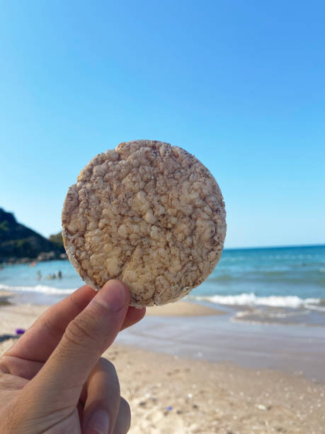 istock Hand holding crunchy wholewheat snack at the beach 1409900576