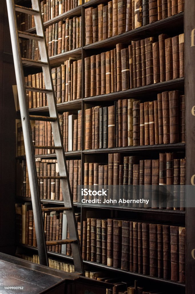 Shelves stacked with old leather bound books of the old library of Trinity College Dublin; the Long Room. Over 200,000 books are kept in the Long Room which is the old library of Trinity College Dublin including the Book of Kells. It has been a working library since 1732. History Stock Photo