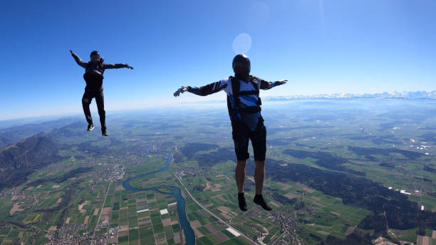 istock Skydivers fall through clear skies, aerial flight 1409905199