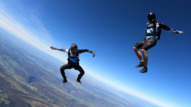 istock Skydivers fall through clear skies, aerial flight 1409905309