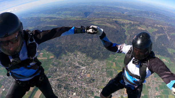 istock Skydivers fall through clear skies, aerial flight 1409905325
