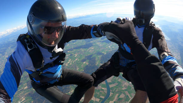 istock Skydivers fall through clear skies, aerial flight 1409905364