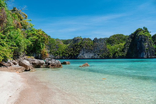 Close-up shot of beautiful remote beach in Raja Ampat Islands, with turquoise sea water and white sand beach