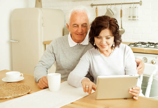 istock Elderly husband and wife using digital tablet at home 1409908360