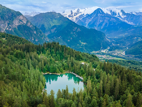 View of Mont Blanc and Lac Vert in Alps mountains near Chamonix, France. Summer French alpine scenery with fir tree forest, lake and green valley.