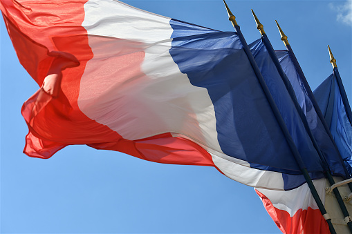 Group of French flags fluttering in the wind on the occasion of the national holidays, Paris, France.
