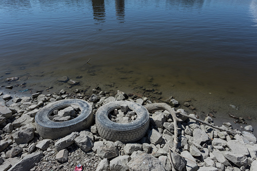 Water pollution, truck tires on river bank
