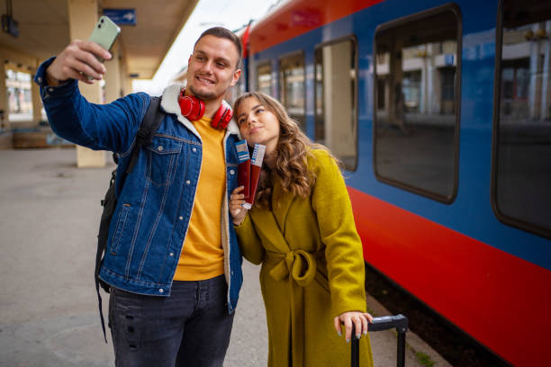 istock Young couple taking selfies while waiting on train station 1409913840