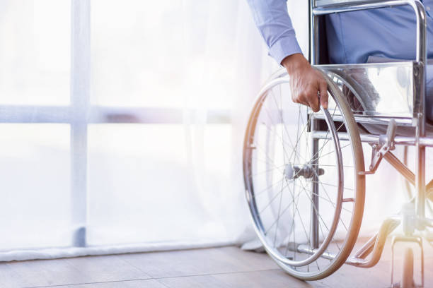 diseased man is sitting in a wheelchair, He holds his hands on the wheel wheelchair Recovery and healthcare concepts. diseased man is sitting in a wheelchair, He holds his hands on the wheel wheelchair Recovery and healthcare concepts. wheelchair lift stock pictures, royalty-free photos & images