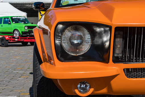 Praia Grande, São Paulo - Brazil - July 25, 2021: Puma GTB in orange color. Headlight and grille. Brazilian vintage car from the 70s.