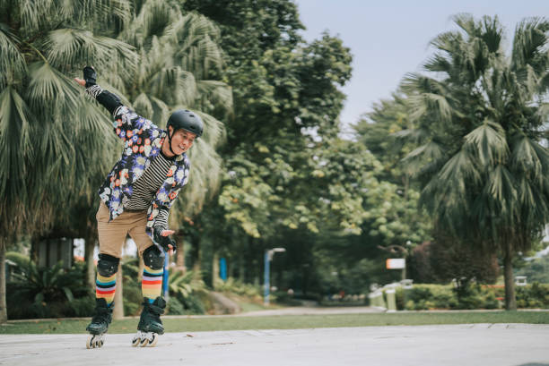 Asian Chinese gay person practicing inline skating in public park