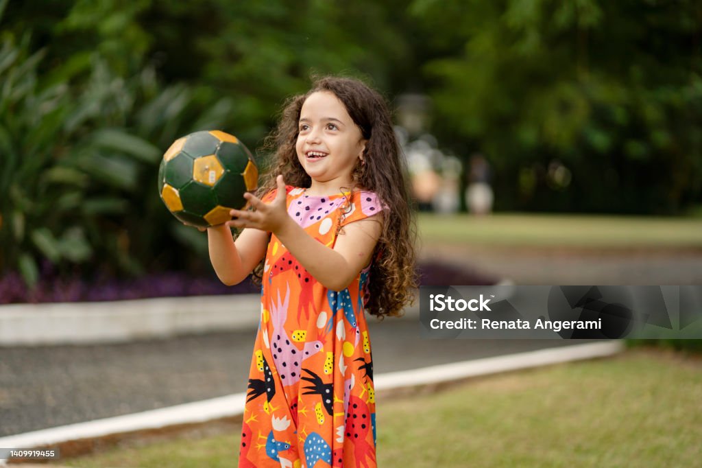 Little girl playing with soccer ball in the park Child Stock Photo