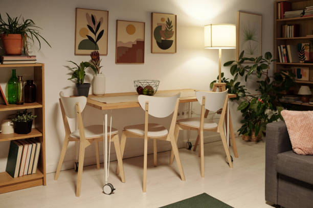 istock Several chairs standing around dinner table by wall with group of paintings 1409921426