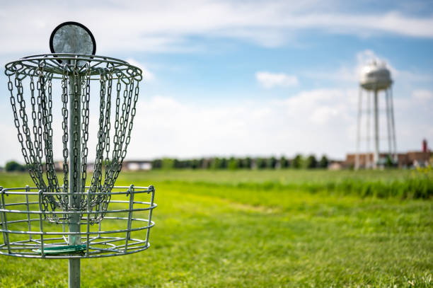 istock Disc golf goal chains gently swaying in the breeze with a green course in the background 1409922017