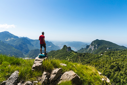 hiker standing on top mountain looking at panorama