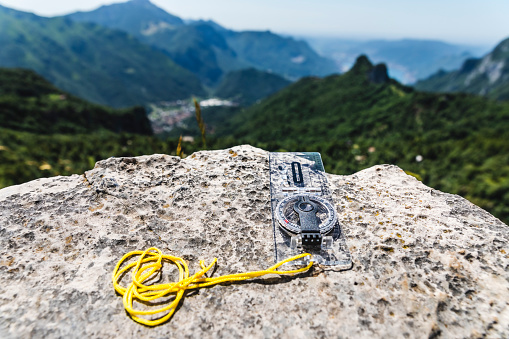hiking compass for orientation resting on a mountain stone