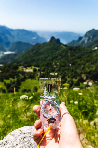 istock Human hiker left hand with compass, forest in valley background 1409923369