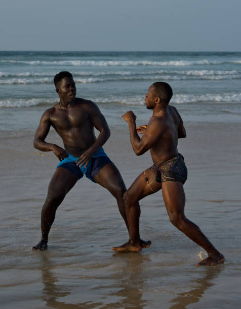 A group of wrestlerson the seashore Dakar. Senegal. October 13, 2021. A group of Senegalese wrestling fighters Laamb on the sandy seashore conducts a ritual dance before the fight, showing the opponent strength. wrestlers uniform stock pictures, royalty-free photos & images