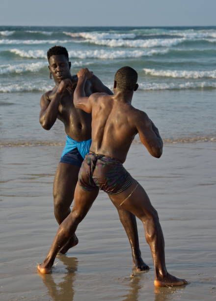 A group of wrestlerson the seashore Dakar. Senegal. October 13, 2021. A group of Senegalese wrestling fighters Laamb on the sandy seashore conducts a ritual dance before the fight, showing the opponent strength. wrestlers uniform stock pictures, royalty-free photos & images