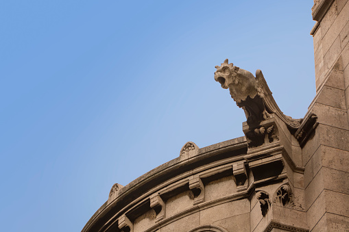 Gargoyle on the facade of the Sacre Coeur Basilica. Paris, France.