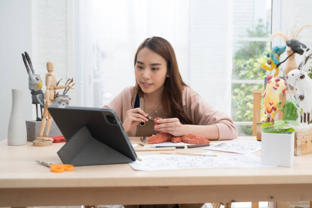 istock Young Asian girl making a sculpture with modeling clay form learn from the internet online at home .hobby clay sculpt concept 1409931466