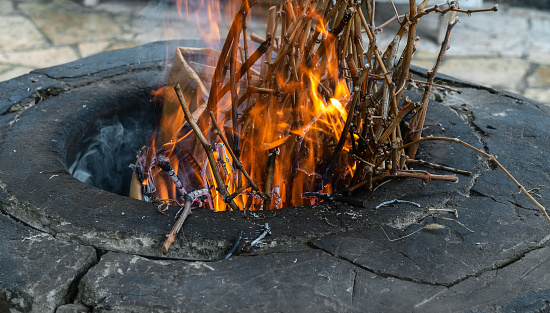 Traditional Caucasian wood-burning stone-brick tandoor oven for cooking shish kebab, fish, pita bread.