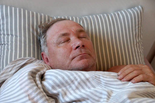 istock sick man lying in bed with closed eyes 1409935005
