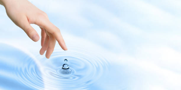 istock Finger touches water close up. Copy space 1409935736
