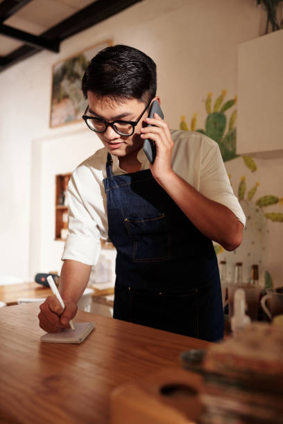 istock Cafe Waiter Talking on Phone 1409940059