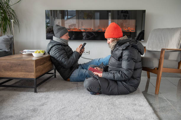 Family at home in winter clothes it's cold they freeze save energy stock photo