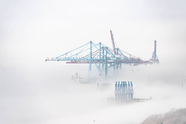 Gothenburg, Sweden - April 14 2022: Container cranes at Skandiahamnen in dense local fog.