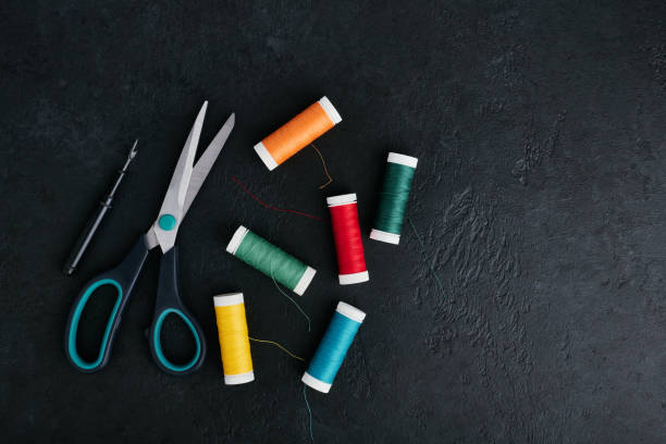 istock Reels of thread scattered on the table, tailors scissors and thread cutter 1409942627